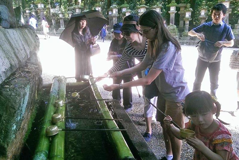 Visitors washing at fountain before entering Todai-ji Temple, Nara, Japan. 
