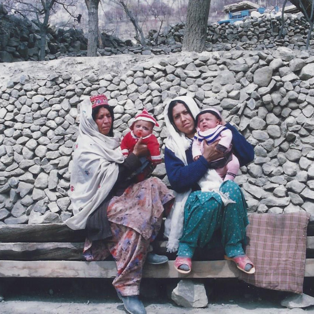 Two women with twin babies outside a home in Hunza, Pakistan