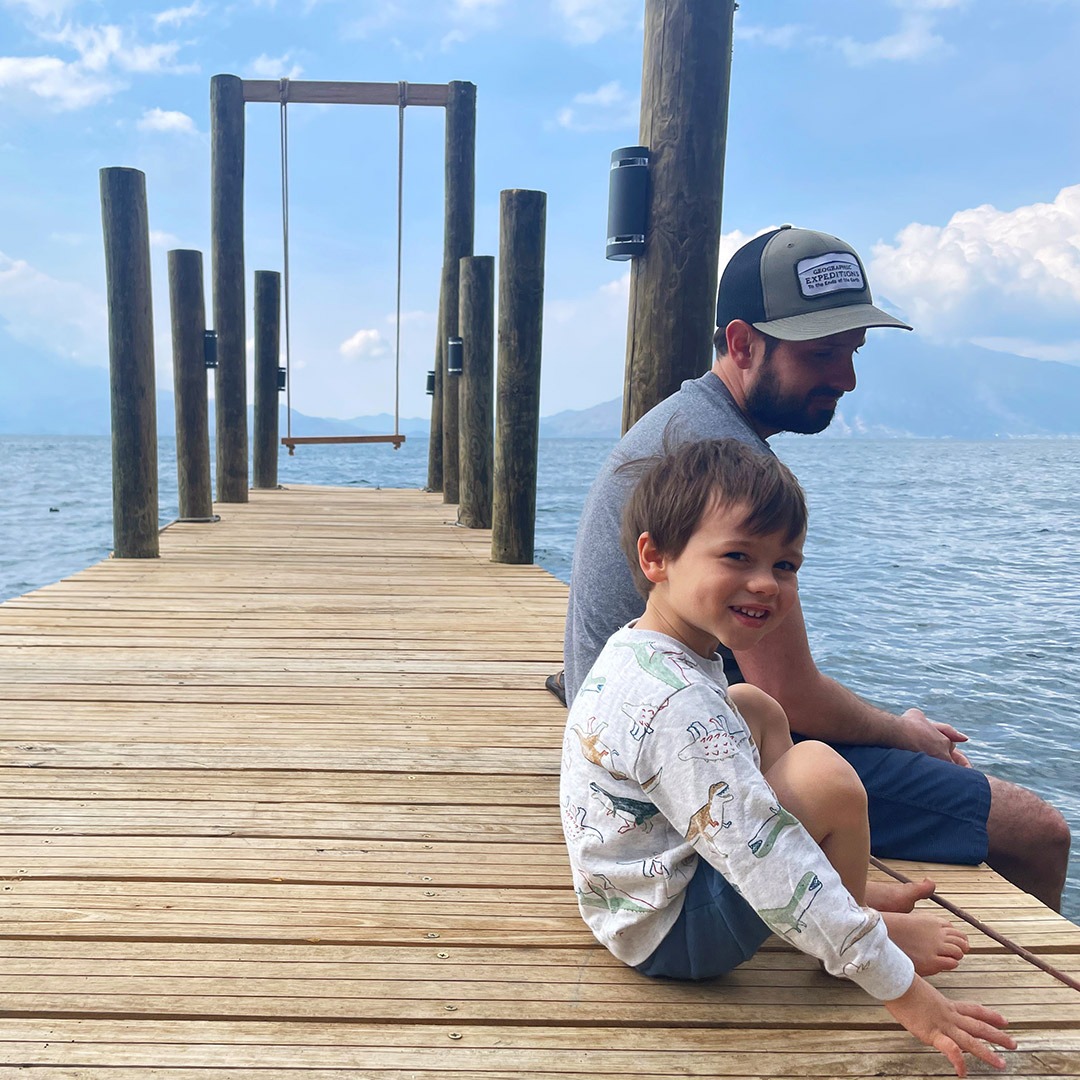 GeoEx's Alex Yalch sitting on a deck at Lake Atitlan with his son